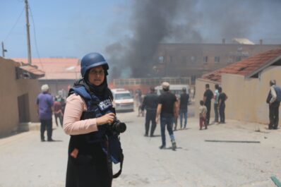 Female war reporter in a conflict zone